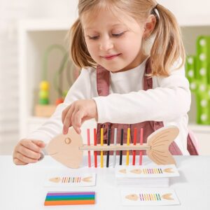Dziewczynka układa kolorowe pałeczki na drewnianej rybie według karty