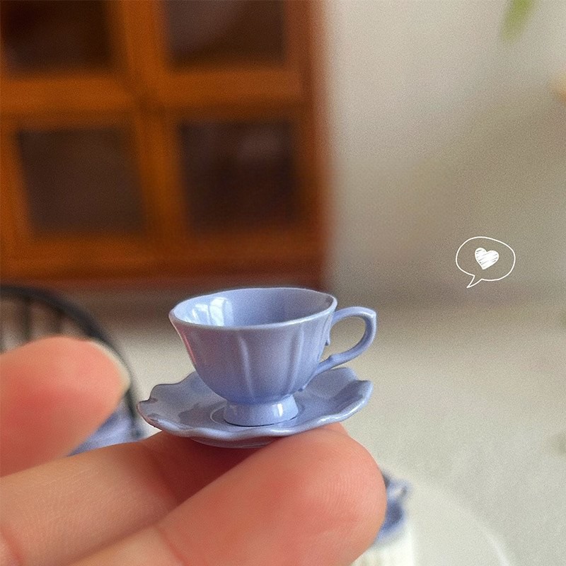 Lawendowa miniaturowa filiżanka trzymana w palcach