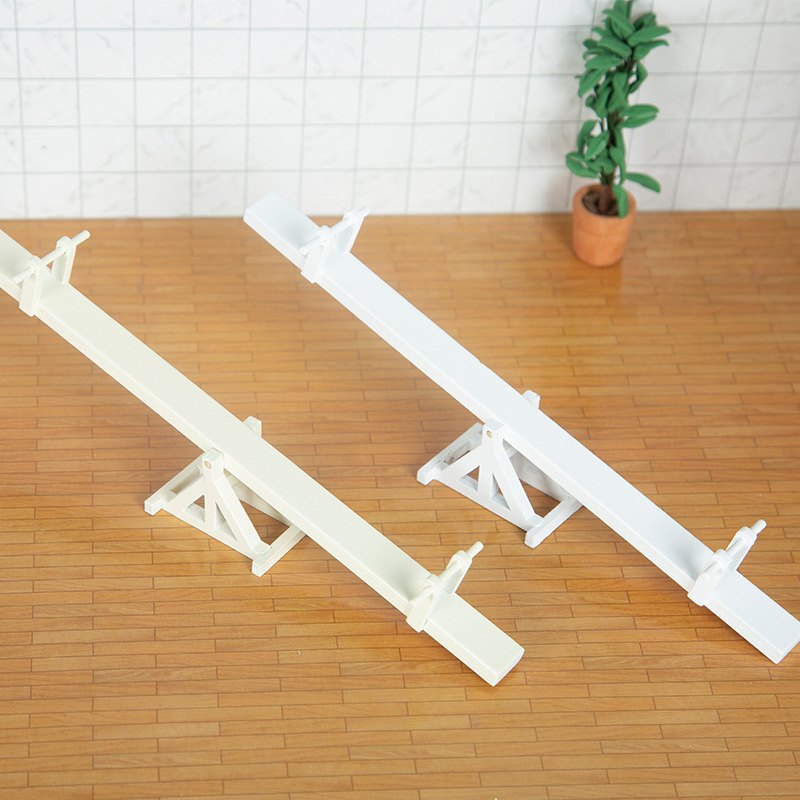 Dwie miniaturowe równoważnie na drewnianej podłodze obok rośliny